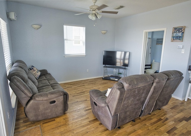 living room featuring ceiling fan, a healthy amount of sunlight, and wood-type flooring