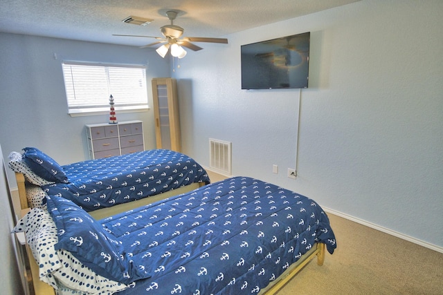 carpeted bedroom with ceiling fan and a textured ceiling