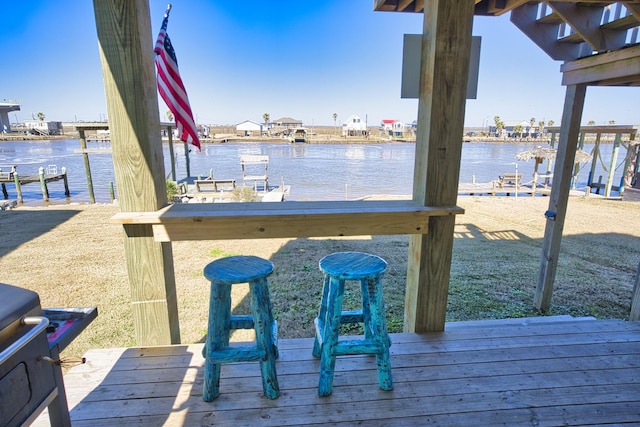 view of dock featuring a deck with water view and an outdoor bar