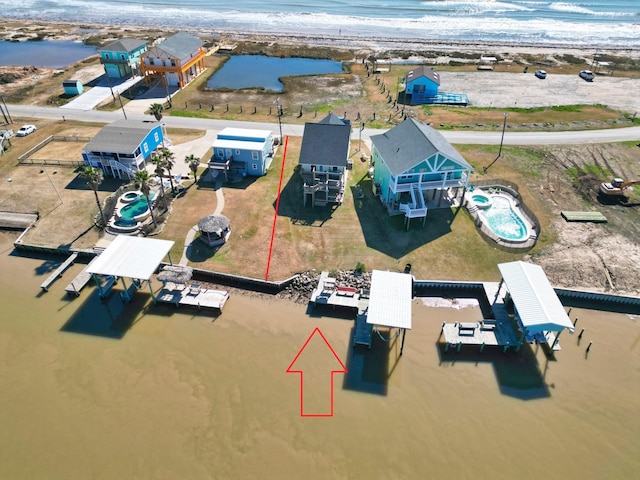 drone / aerial view featuring a water view and a beach view