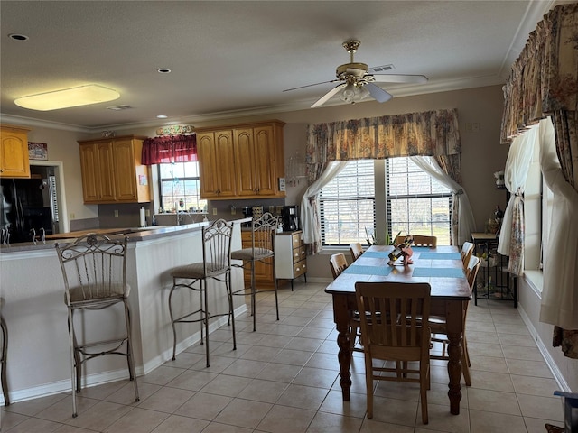 dining room featuring crown molding, ceiling fan, and light tile patterned floors