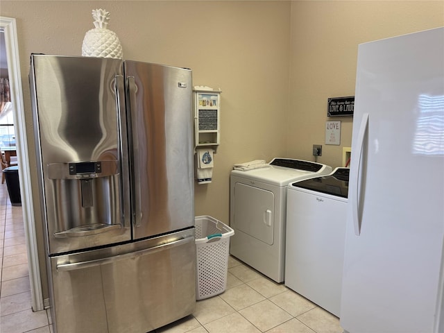 washroom with independent washer and dryer and light tile patterned floors