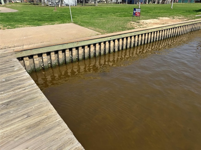 dock area with a water view and a yard