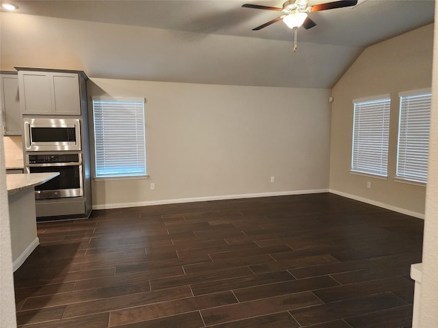 interior space with ceiling fan, appliances with stainless steel finishes, lofted ceiling, and dark hardwood / wood-style flooring