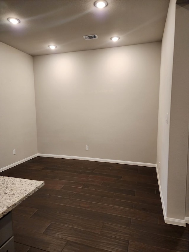 unfurnished room with dark wood-type flooring