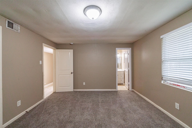 spare room featuring carpet and a textured ceiling