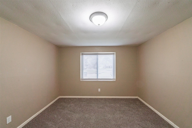 empty room with carpet and a textured ceiling