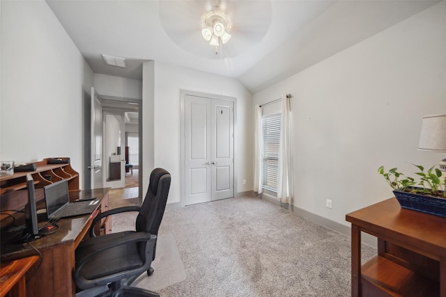 carpeted office space with lofted ceiling, a ceiling fan, visible vents, and baseboards