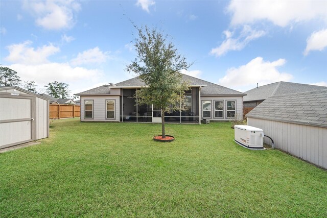 back of property with a sunroom, a yard, and a storage shed