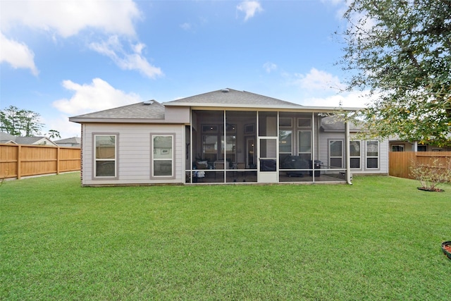 back of house with a sunroom and a lawn