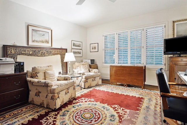 living area featuring hardwood / wood-style floors and ceiling fan