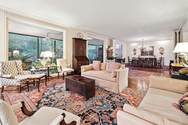 living room with a notable chandelier, crown molding, and hardwood / wood-style flooring