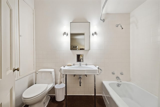 bathroom with toilet and tile walls