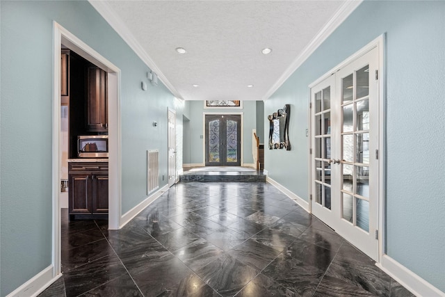 foyer entrance featuring ornamental molding, french doors, and a textured ceiling