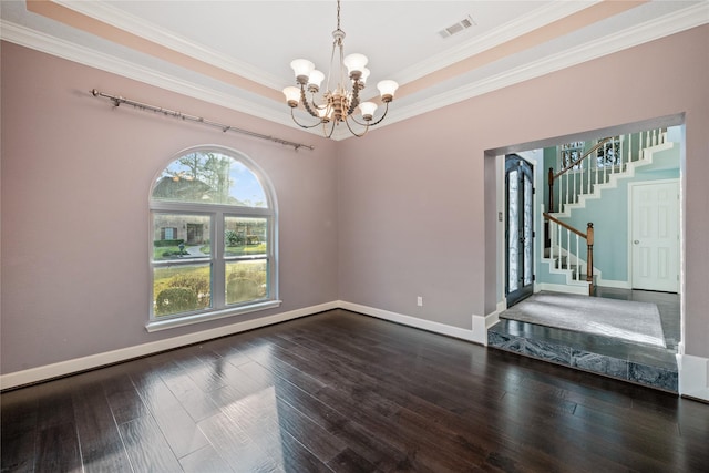 unfurnished room featuring crown molding, a tray ceiling, dark hardwood / wood-style floors, and a chandelier