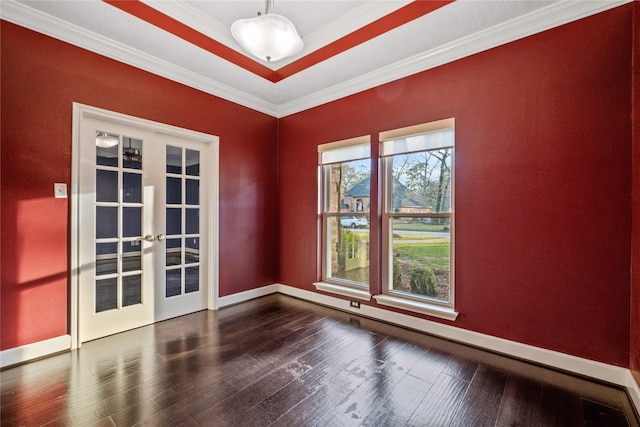 empty room featuring french doors, dark hardwood / wood-style floors, a raised ceiling, and crown molding