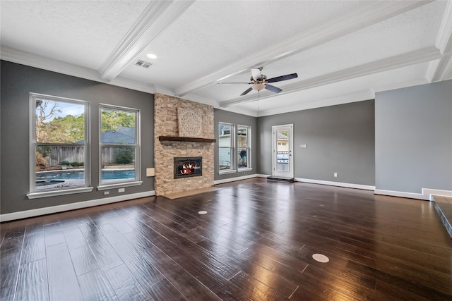 unfurnished living room featuring ceiling fan, a fireplace, a textured ceiling, dark hardwood / wood-style flooring, and beamed ceiling