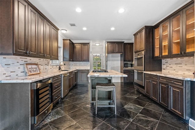 kitchen featuring a kitchen island, sink, wine cooler, and dark brown cabinetry