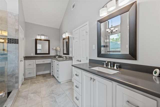 bathroom featuring vanity, lofted ceiling, a tile shower, and a notable chandelier