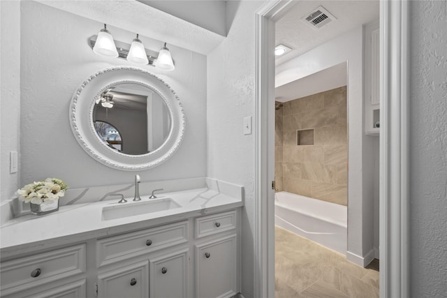 bathroom with vanity and tiled shower / bath