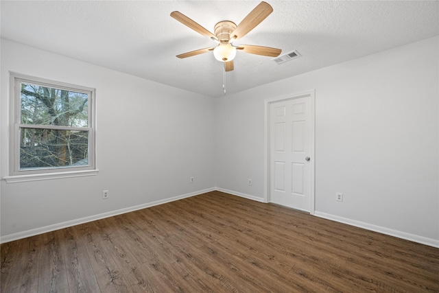 spare room with dark hardwood / wood-style floors, a textured ceiling, and ceiling fan