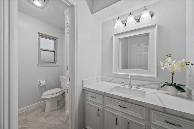 bathroom with vanity, a textured ceiling, and toilet