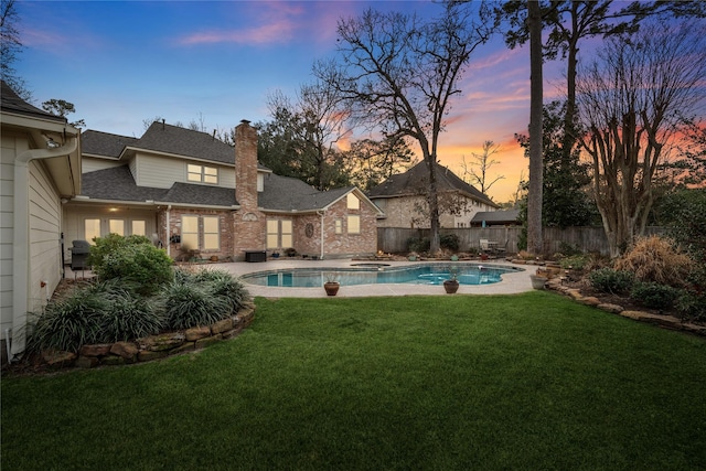 pool at dusk with a grill and a lawn