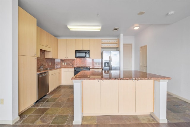 kitchen featuring stainless steel appliances, light brown cabinetry, a center island, and backsplash