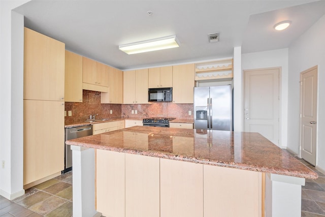 kitchen with stainless steel appliances, tasteful backsplash, a kitchen island, and light stone counters