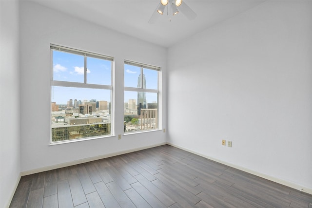 empty room with hardwood / wood-style flooring, plenty of natural light, and ceiling fan