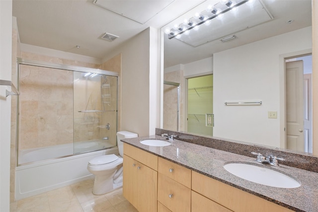 full bathroom featuring vanity, tile patterned flooring, combined bath / shower with glass door, and toilet