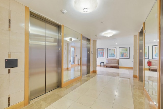 hall featuring elevator and light tile patterned floors