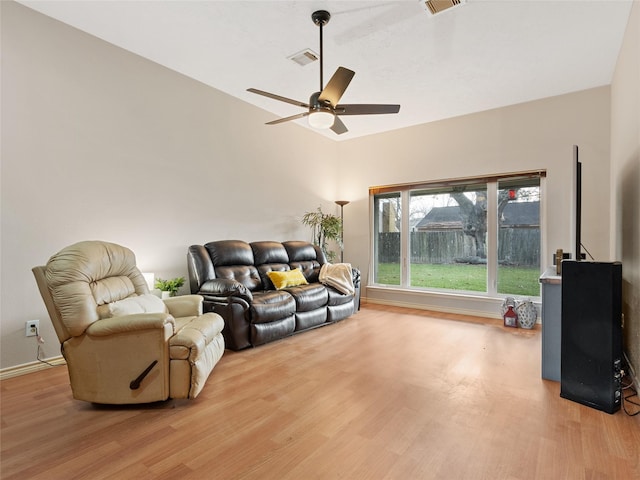 living room with wood-type flooring, vaulted ceiling, and ceiling fan