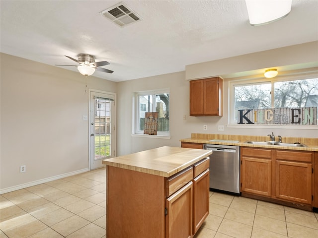 kitchen featuring sink, a center island, stainless steel dishwasher, and light tile patterned floors