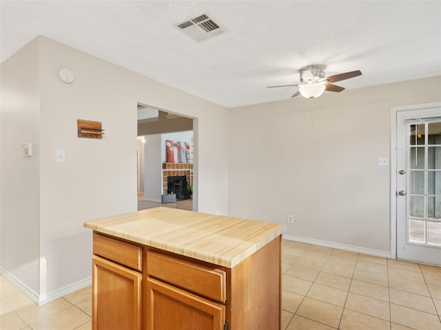 kitchen featuring a center island, ceiling fan, and light tile patterned flooring