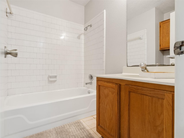 bathroom featuring tiled shower / bath, vanity, tile patterned flooring, and a textured ceiling