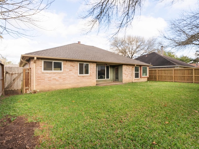 rear view of property with a yard