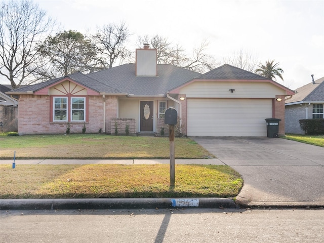 view of front of house with a front yard, brick siding, an attached garage, a chimney, and driveway