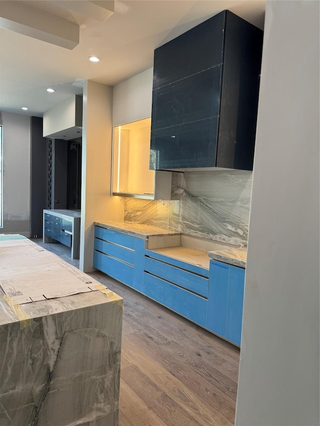 kitchen featuring tasteful backsplash, recessed lighting, blue cabinets, and wood finished floors