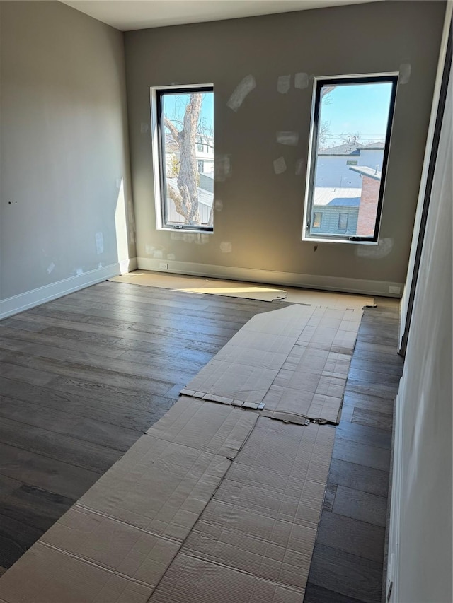 unfurnished room featuring wood finished floors and baseboards