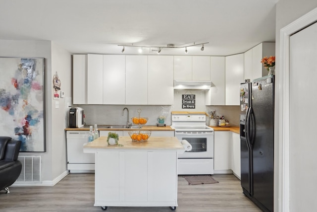 kitchen with sink, backsplash, white cabinets, white appliances, and light hardwood / wood-style flooring