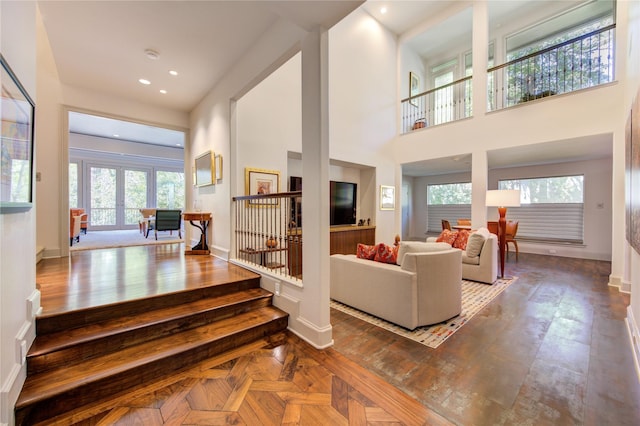 interior space featuring recessed lighting, baseboards, and a high ceiling