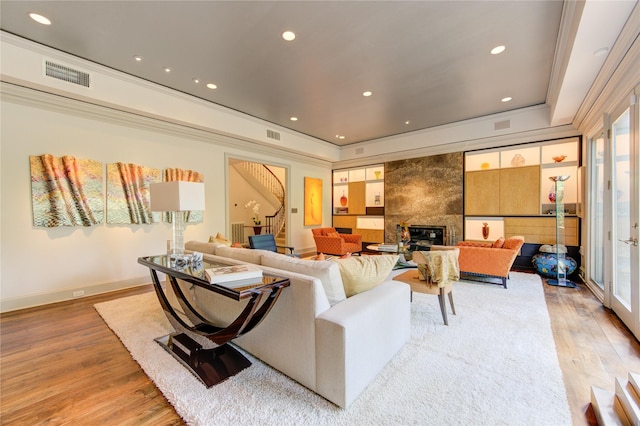 living room with visible vents, a tiled fireplace, recessed lighting, light wood finished floors, and baseboards