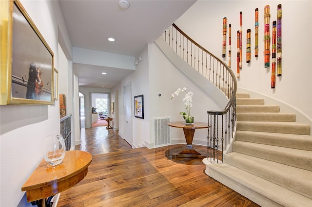 foyer featuring visible vents, baseboards, stairs, hardwood / wood-style floors, and recessed lighting