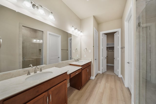 bathroom featuring a shower with door, vanity, and wood-type flooring