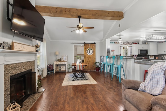 living room featuring dark hardwood / wood-style floors, ornamental molding, and a barn door