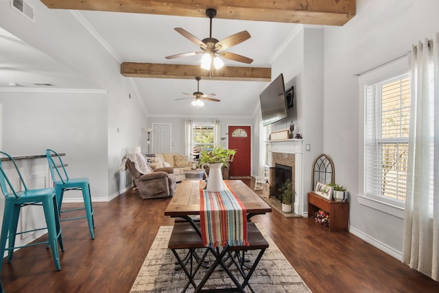 dining room featuring dark wood-type flooring, ornamental molding, and a premium fireplace