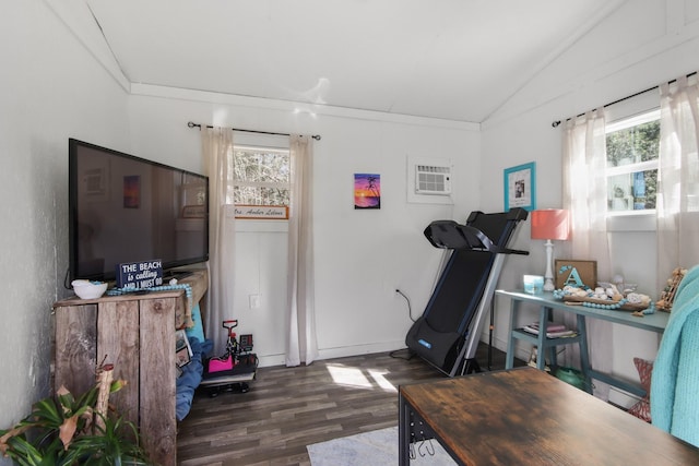 workout room featuring lofted ceiling, dark hardwood / wood-style floors, and an AC wall unit