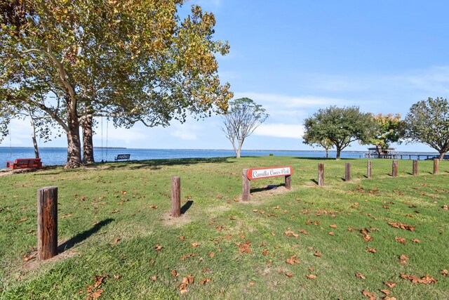 view of community featuring a water view and a yard