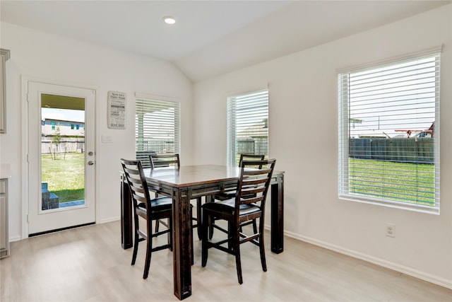 dining space featuring light hardwood / wood-style floors and vaulted ceiling